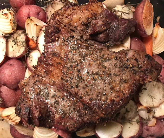 Steak on top of roasted potatoes and onions