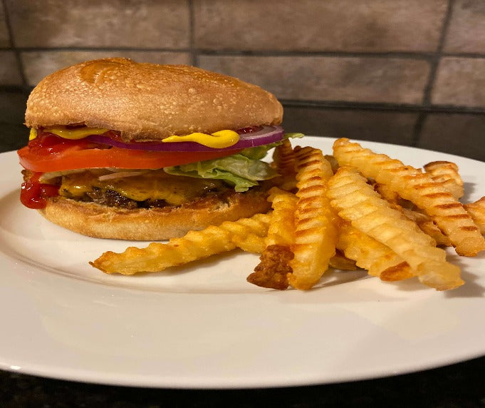 Hamburger with fries, lettuce, tomato, and condiments