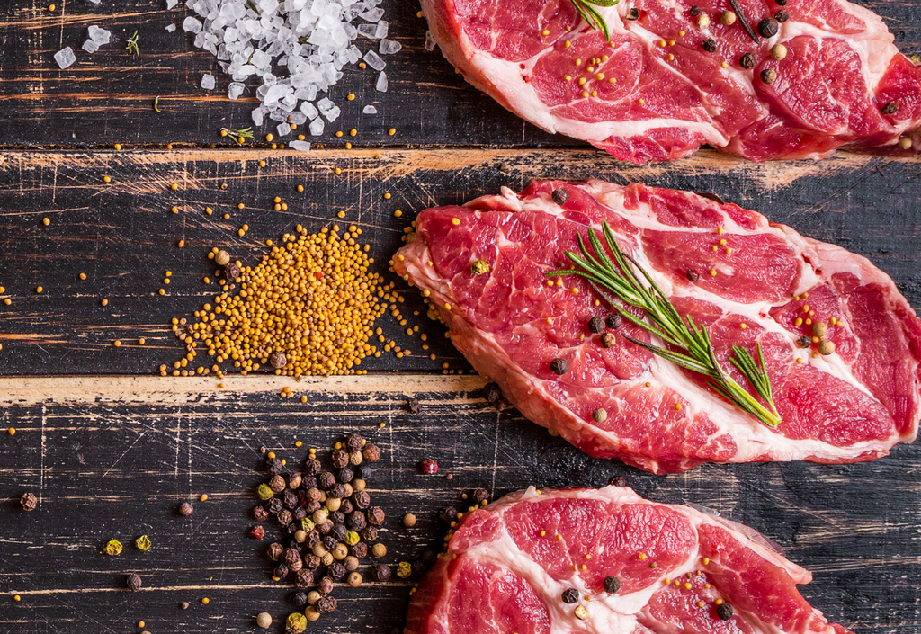 Raw ribeye steaks in a rustic setting